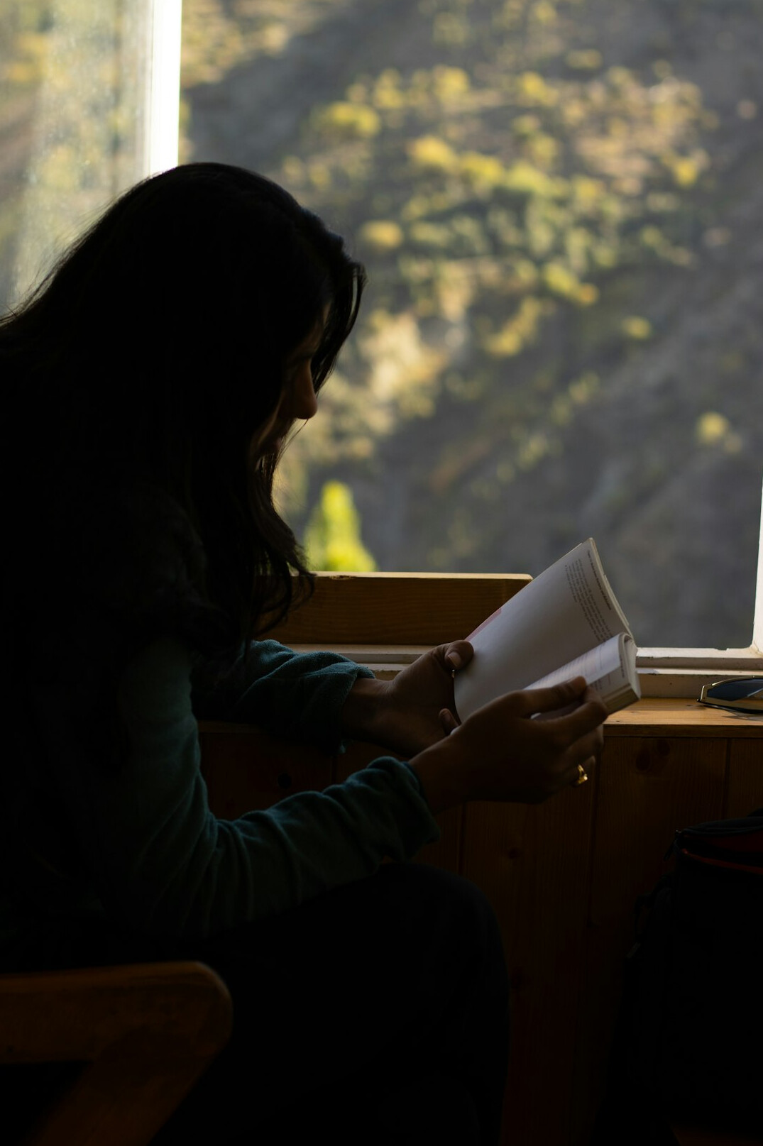 person reading book by window